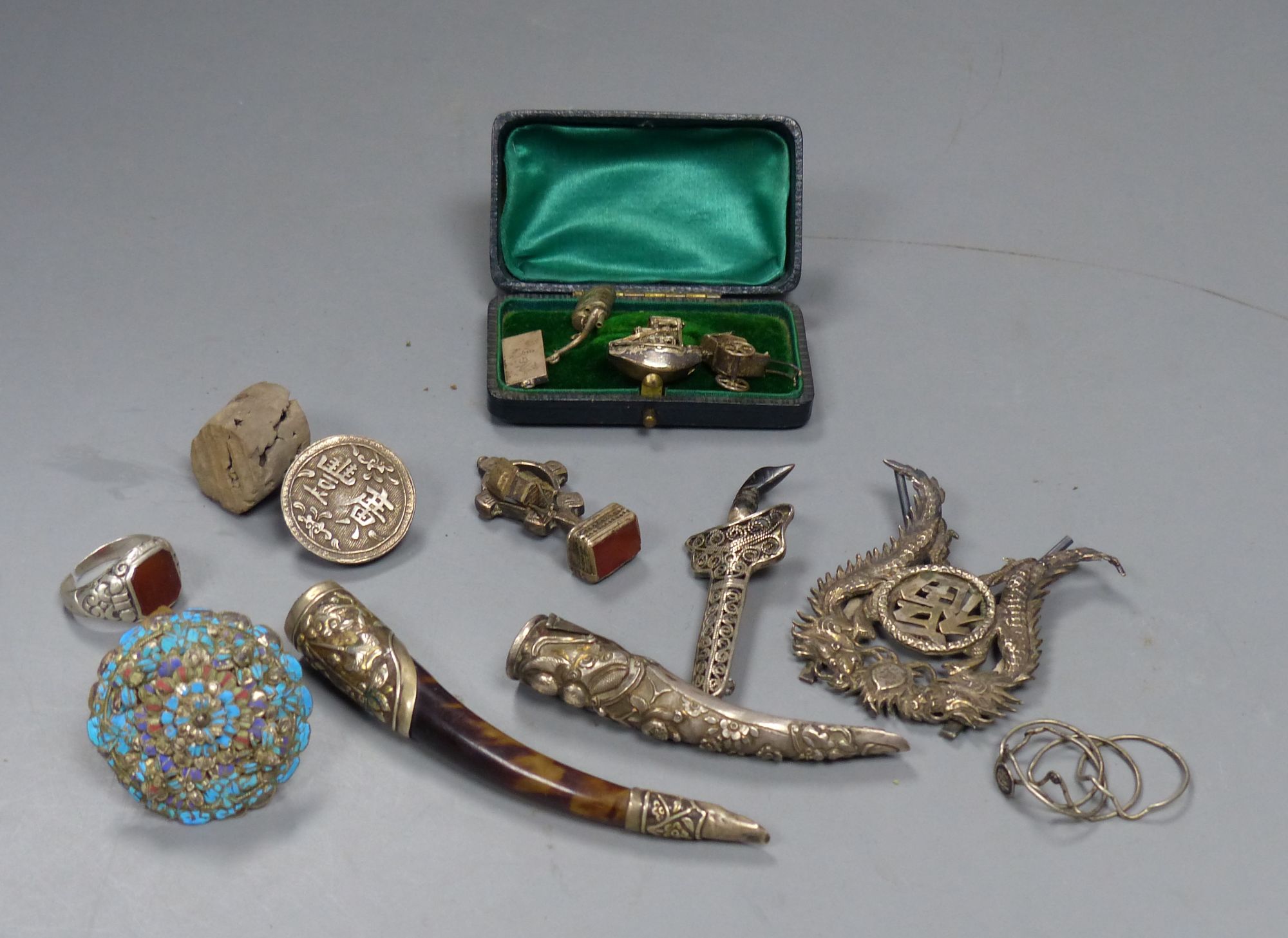Assorted Chinese white metal items including a menu holder, nail guard, charms, brooches etc.
